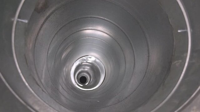 View from inside a galvanized ventilation duct with perspective receding into the depth