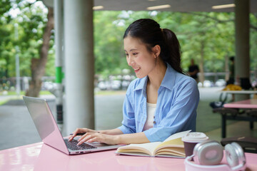 Fototapeta premium Education, university and woman in campus, research and books for school project or exam. Laptop, notebook and internet, college student studying with technology and e learning on campus