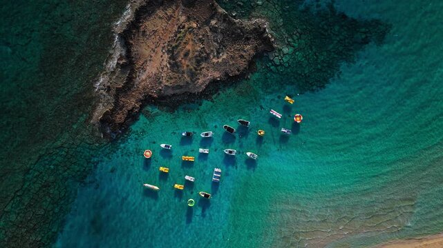 Aerial view of Fig Tree Beach in Protaras, Cyprus. The shallow blue-green bay and moored boats highlight the beach&rsquo;s clear Mediterranean waters.