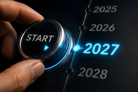 Hand turning a dial to start the year 2027 with a glowing interface on a dark technological background