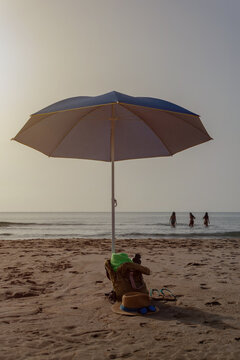 Vertical beach umbrella with backpack and beach accessories by sea