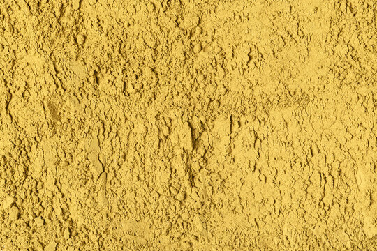 Fine hojicha powder covers frame with uneven golden texture and serves as background for tea packaging, food, and organic design.