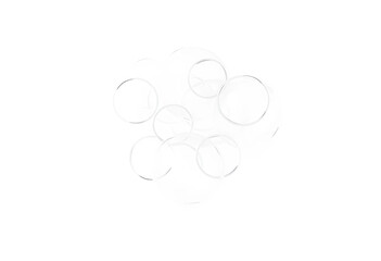 Fototapeta premium Clear glass spheres and rings creating an abstract bubble pattern on a clean white background, the transparent objects create a minimalist and modern design