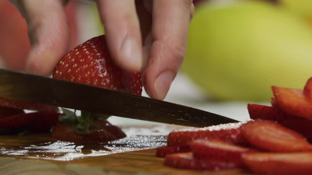 Knife slicing through juicy strawberry - extra closeup shot