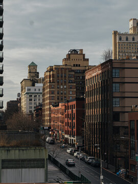 View of the historic Brooklyn streetscape featuring brick buildings, parked cars, and urban architecture in Kings County, New York, United States.