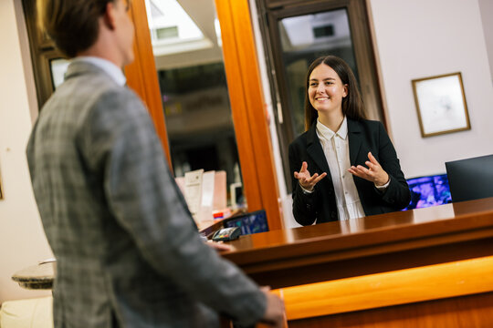 Receptionist assisting business guests at the front desk of a high-end hotel