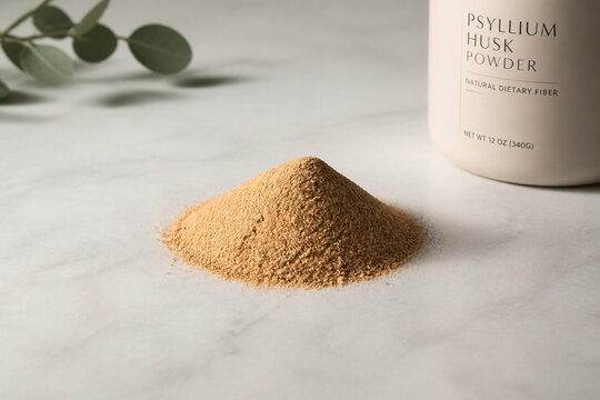Mound of golden-brown psyllium powder on bright surface, natural supplement concept.