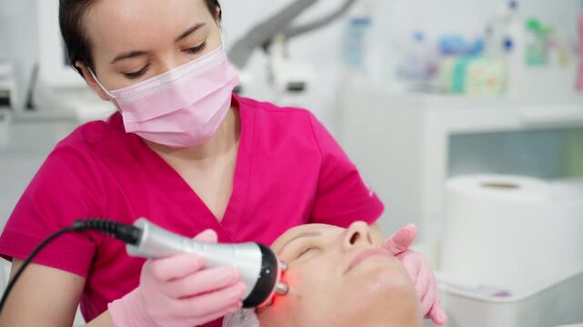 Woman receiving an rf lifting facial treatment from a cosmetologist in a spa clinic, revitalizing her skin with modern anti-aging technology for a smoother complexion