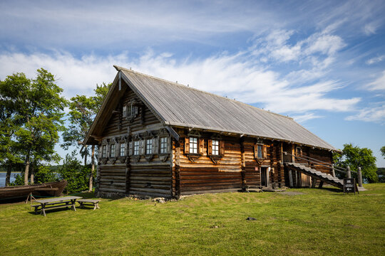 View of the historic wooden architecture of the Kizhi Pogost with traditional log construction and shingled roof set in a grassy landscape in Petrozavodsk, Republic of Karelia, Russia.