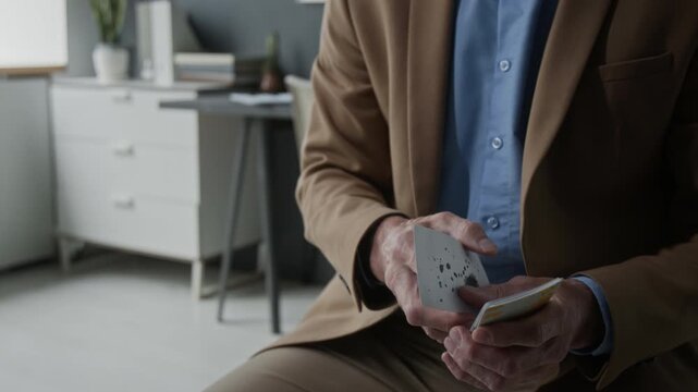 Unknown male psychologist holding and showing Rorschach inkblot test card during therapy session. Perfect for mental health awareness campaigns and psychological services
