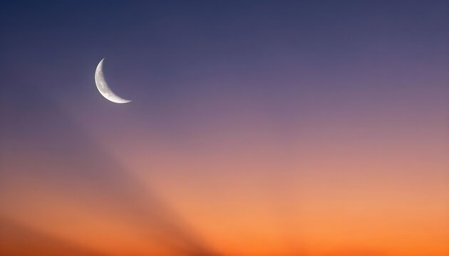 Crescent moon hangs in the upper left corner of a gradient sky at dusk