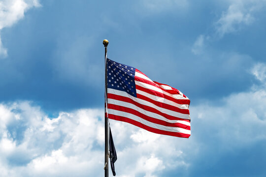 United States Flag Flying Beneath Dramatic Clouds Symbolizing Patriotism Freedom And National Heritage Today