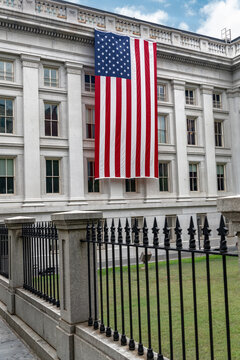 Perimeter fence leads toward the US Treasury Building and large flag in Washington DC.