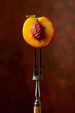 Half a fresh nectarine on a fork.