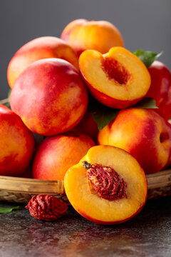 Fresh nectarines on a black stone table.
