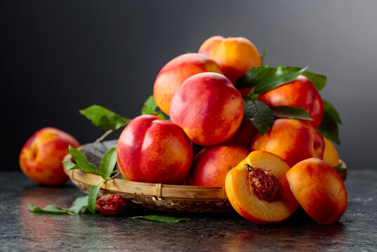 Fresh nectarines on a black stone table.