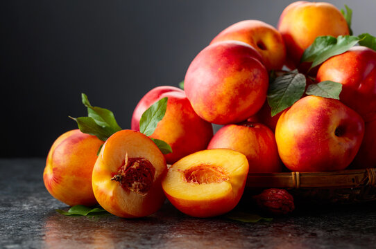 Fresh nectarines on a black stone table.