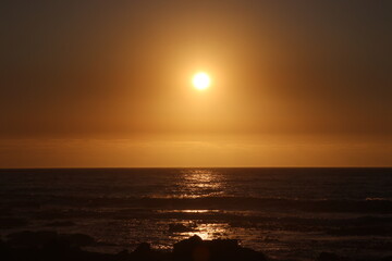 Golden sunset over the Atlantic Ocean with calm sea and glowing reflection © Nikhil Daya
