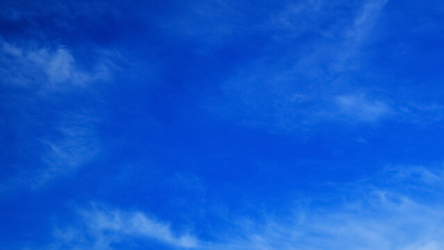 clear bright blue sky with light feathery clouds on a sunny day