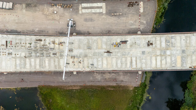 Aerial view of the Black Cat Roundabout construction site, showing the bridge deck, construction equipment, and surrounding landscape in Chawston, England, United Kingdom.