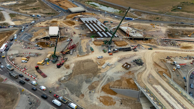 Aerial view of the Black Cat Roundabout construction site featuring heavy machinery, cranes, and ongoing road infrastructure development in Chawston, England, United Kingdom.