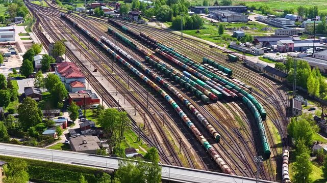 Aerial view of a busy railway yard with multiple freight trains and tracks in Riga, Latvia.