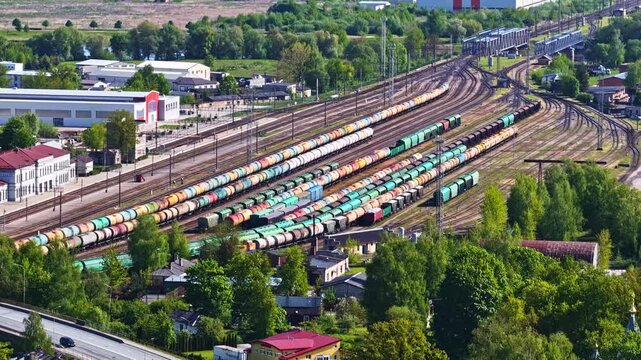 Aerial view of freight trains and cargo wagons on multiple tracks at a busy railway yard in Riga, Latvia.