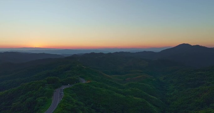 Aerial view of the iconic number three shaped road in Nan, Thailand. The winding mountain road curves through lush green forest and hills, creating a famous scenic viewpoint and popular photography