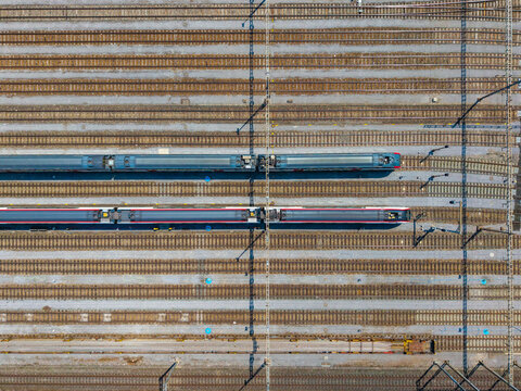 Aerial view of Daniken train station with two passenger trains parked on parallel tracks in Daniken, Solothurn, Switzerland.