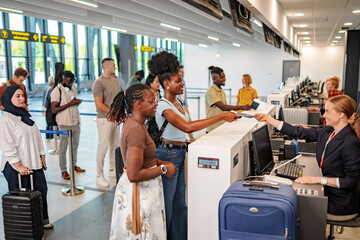 Fototapeta premium Diverse passengers checking in at airport with airline staff