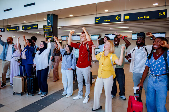Diverse group of friends celebrating journey in airport terminal