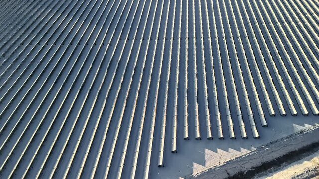 Aerial view of a large solar farm with rows of photovoltaic panels capturing sunlight for renewable energy production in Latvia.