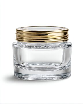 Studio shot of a clear glass jar with a gold lid on a white background for beauty products and cosmetics