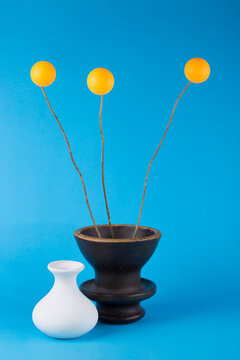 Abstract still life with a vase and orange balls on a blue background