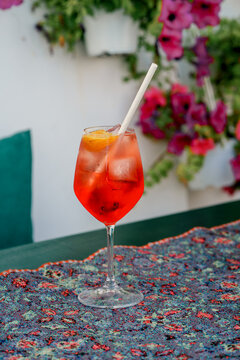 Red aperitif with ice and orange on a cafe table. Concept of relaxation, travel, refreshment, summer, lifestyle. Aperol Spritz and Campari Spritz