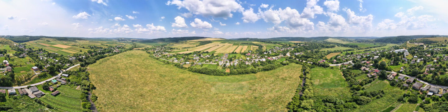 Aerial landscape view of green and yellow cultivated agricultural fields with growing crops on bright summer day