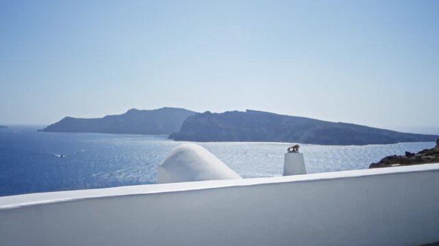 Santorini coastal background with blurred bokeh sea and defocused island beyond white wall foreground outdoor; background backdrop copyspace calm.