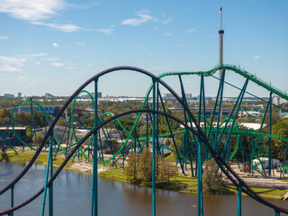 Fototapeta premium Orlando attraction park showcases roller coasters and festive atmosphere in sunny Florida. Popular tourist destination delivers joy, thrills and recreation.