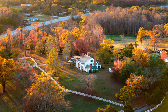 Rural homes and mansions on wooded slopes of Tennessee in colorful fall season. Scenic autumn view of Appalachian forest hills.
