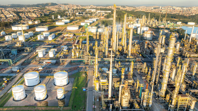 Aerial view of the petrochemical complex featuring industrial storage tanks and distillation towers set against an urban landscape in Santo Andre, State of Sao Paulo, Brazil.