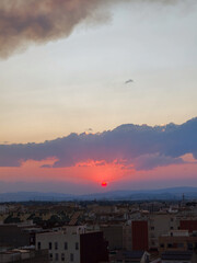 Obraz premium Red sun setting over almassora urban skyline