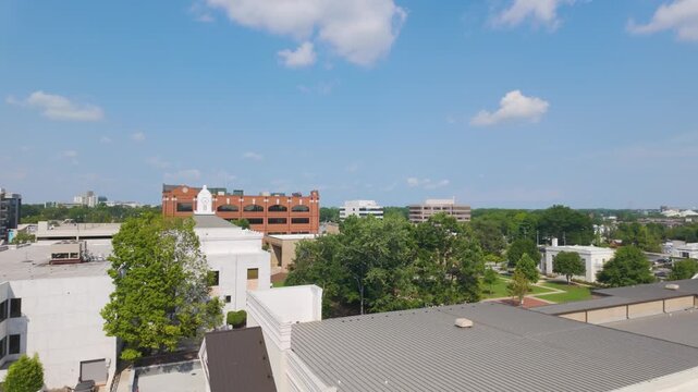 Sunny view of the historic town square in downtown Gainesville, Georgia. Classic brick buildings, tree-lined streets, and the central square create a charming Southern downtown scene