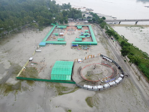 Drone view of fairground construction site beside a river with fairground construction development infrastructure assembly structures preparation temporary installation building