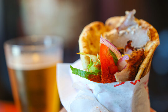 A freshly made Greek gyro served with a cold beer in Santorini, Greece &mdash; a flavorful taste of Mediterranean street food and local culinary tradition.