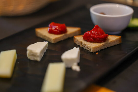 A Mediterranean appetizer of Greek cheese and bread topped with tomato spread, served in Santorini &mdash; a simple yet flavorful taste of local cuisine.