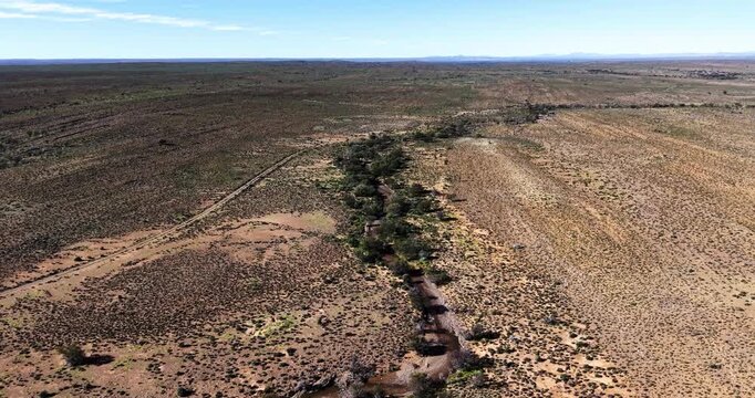 Aerial drone view of a seasonal river winding through the semi-arid Great Karoo near Prince Albert in the Western Cape, South Africa.