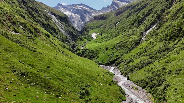 Scenic mountain valley with a stream and hiking trail leading towards Hochfeiler peak in the Zillertal Alps.