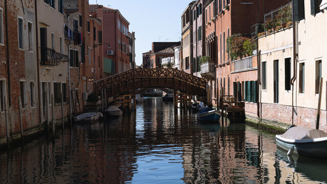 Narrow canal of Venice, gondolas on the water, architecture of buildings