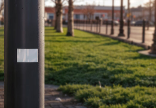 Blank rectangle sticker mockup on outdoor metal pole, ai generated. White label attached on pole in urban environment. Ideal for showcasing custom sticker designs, branding, street advert and logos.