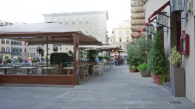 Blurred outdoor cafe street background with shallow bokeh and soft focus; background backplate template calm.